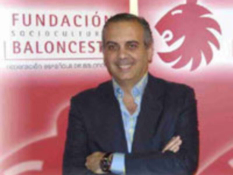 Efecto de un hombre sonriente en una foto con una fundación baloncesto en el fondo.