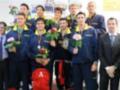 Equipo de nadadores posando con medallas y flores, celebrando un triunfo en una competencia de natación.