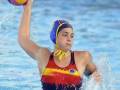 Joven jugadora de waterpolo en acción, lanzando el balón en una piscina.