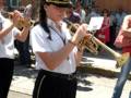 Mujer tocando trompeta en un desfile militar.