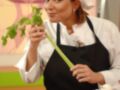 Una mujer en uniforme de chef sostiene una espina de ajo, con verduras y especias alrededor. La imagen promueve una cocina saludable y educativa.