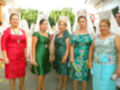 Una grupo de mujeres vestidas con trajes tradicionales, posando en una celebración.