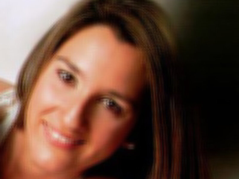 Retrato de mujer sonriente con cabello largo y ligeramente desenfocado.