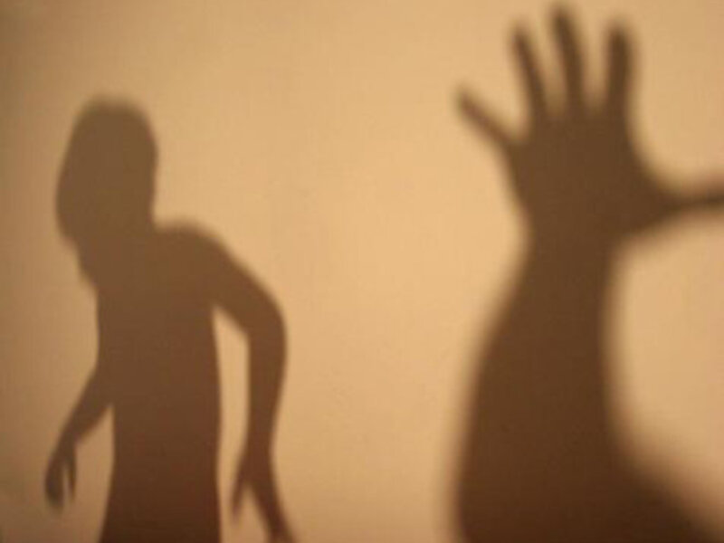 Sombra de una figura humana con una mano levantada, representando un gesto de protección o resistencia.