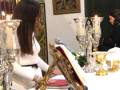 Una mujer se sienta en un elegante salón con velas y adornos navideños, posiblemente en una celebración especial.