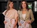 Dos mujeres sonrientes sostienen revistas de moda en una presentación.
