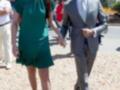 Imagen de una pareja caminando, la mujer lleva un vestido verde y el hombre un traje gris. Fondo de una calle con otros individuos a la distancia.
