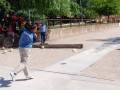 Jugador lanzando una pelota de boliche en un juego al aire libre.