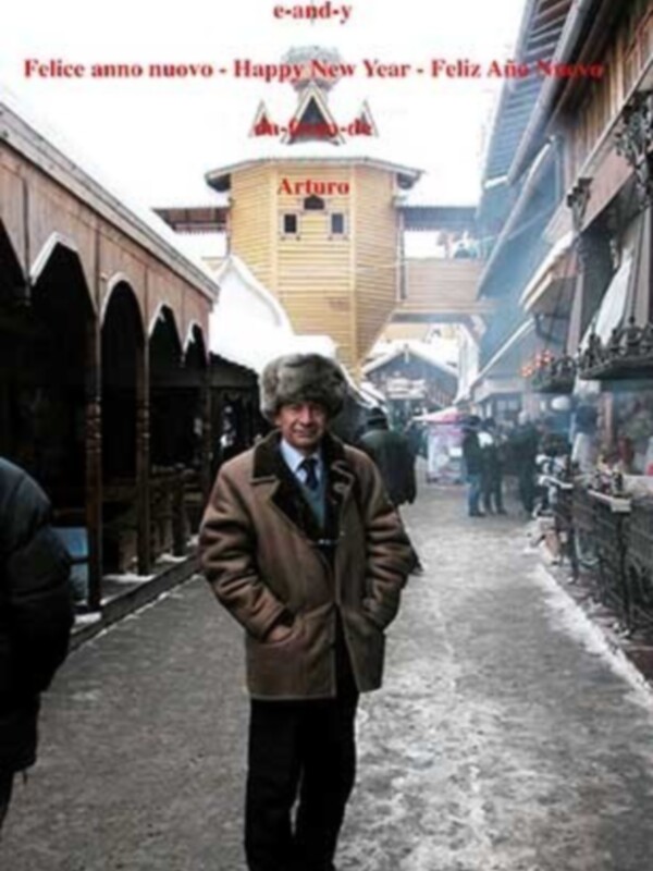 Un hombre camina por una calle nevada, rodeado de tiendas y edificios con decoraciones navideñas. La imagen incluye saludos navideños en varios idiomas.