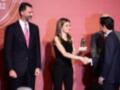 Una mujer entrega un premio a dos hombres en una ceremonia formal.