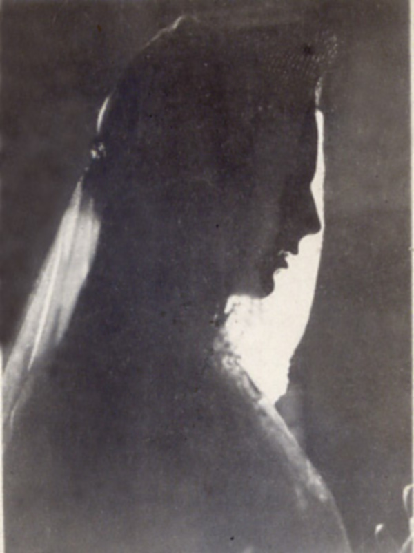 Silueta de perfil de una figura humana en una imagen en blanco y negro, con sombras dramáticas y textura de la superficie de la imagen.