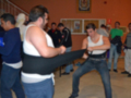 Un grupo de personas en una clase de artes marciales, con un instructor y varios estudiantes.