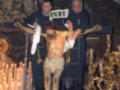 Imagen de Jesús crucificado en la iglesia, con detalles dorados y velas encendidas en el fondo.