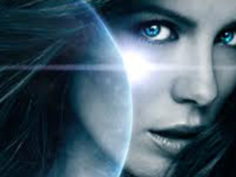 Una mujer con cabello largo y azul brillante, mirando hacia la derecha. La imagen está en blanco y negro con un efecto de luz azul brillante que se extiende hacia la izquierda.