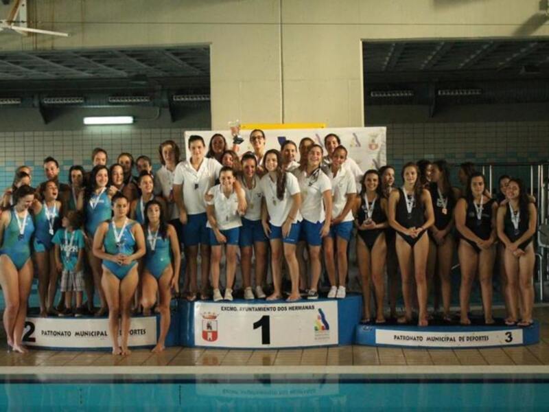 Equipo de natación femenino celebrando en el podio de un torneo deportivo.