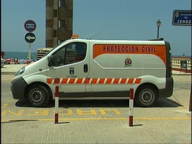 Vehículo de Protección Civil aparcado en una zona urbana junto al mar.