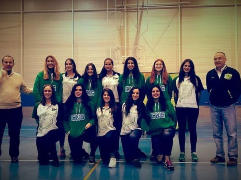 Equipo de baloncesto femenino posando en el gimnasio.
