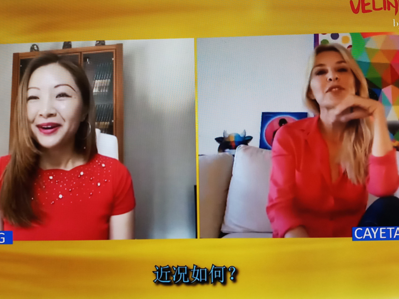 Dos personas en una videollamada, una con cabello largo y una con cabello largo y rojo. La imagen tiene un fondo amarillo con texto en chino.