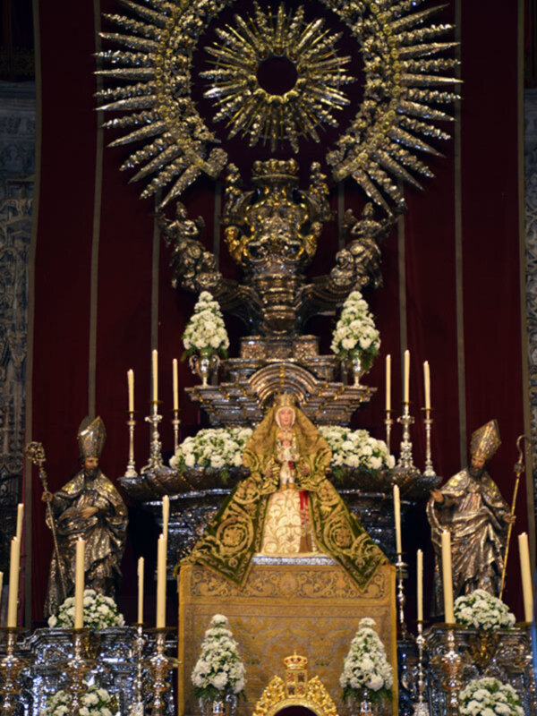 Altar con estatua de la Virgen María y adornos dorados en una iglesia católica.
