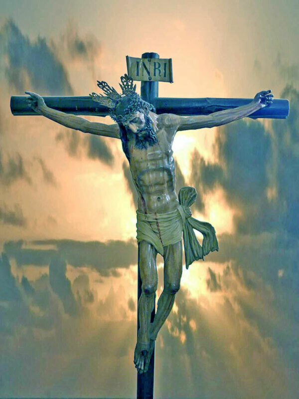 Imagen de Jesucristo crucificado con un cielo nublado en el fondo. La cruz tiene una inscripción que parece ser "INRI".