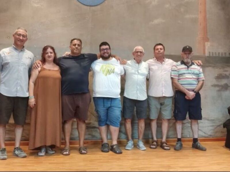 Grupo de personas posando juntos en un salón con un fondo decorativo.