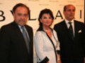 Tres personas posan juntas en un evento formal, con una mujer en el centro y dos hombres a sus lados. La imagen parece ser de un evento empresarial o social, posiblemente relacionado con la marca Bvlgari.