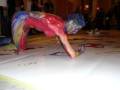 Artista pintando con cuerpo en evento público.