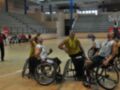Jugadores de baloncesto en silla de ruedas compiten en un partido en una cancha deportiva.