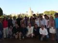 Gruppo di persone in posa per una foto di gruppo all'aperto con vista sul Torre del Oro a Siviglia.