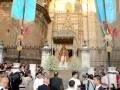 Fotografía de una procesión religiosa frente a la Catedral de Toledo, con banderas y un altar en el centro.