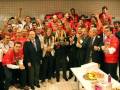 Equipo de fútbol celebrando con trofeo en el vestuario.
