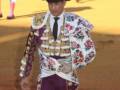 Un torero en traje tradicional de matador, con un sombrero de copa y un chaleco bordado.