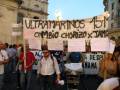 Manifestantes con pancartas en una protesta, incluyendo un gran cartel que dice "ULTRAMARINOS CAMBIO CHORIZO X JAMO".