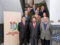Grupo de personas en trajes posando frente a un cartel con el logo del Colegio Territorial de Administradores de Fincas de Sevilla.