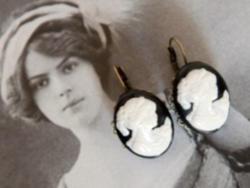 Elegantes pendientes de encaje blanco y negro con detalles dorados, diseñados para un estilo vintage elegante.