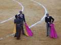 Un torero celebra con un compañero en la plaza de toros.