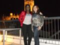 Dos mujeres posan en una terraza nocturna frente a la Giralda, símbolo de Sevilla.
