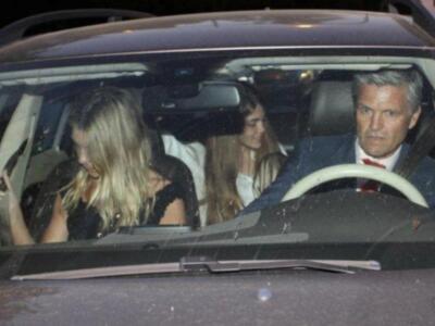 Una familia en un viaje nocturno, con una madre y dos hijas sentadas en el auto. El padre está al volante, todos con expresiones serias y concentradas.