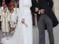 Una boda en una iglesia con un novio besando a su novia vestida de blanco.