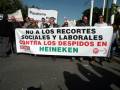 Manifestantes sostienen un cartel que denuncia recortes sociales y laborales contra los despidos en Heineken.