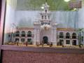 Modelo de una casa colonial con detalles arquitectónicos y esculturas en miniatura.