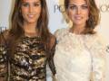 Dos mujeres posando juntas en un evento formal, con vestidos elegantes y maquillaje destacado.