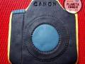 Un protector de cámara con la marca Canon y un logo de Planeta Cookies en el fondo.