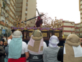 Una procesión religiosa con personas vestidas con velos y portando una imagen en una carroza.