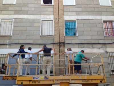 Trabajadores en una plataforma de elevación en una edificación de viviendas.