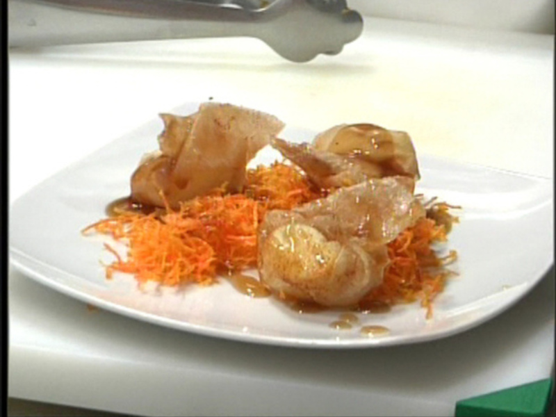 Se muestra un plato blanco con una ensalada de zanahorias y otros ingredientes. La zanahoria está picada finamente y cubre buena parte del plato, mientras que los otros ingredientes parecen estar en forma de trozos o rodajas. La presentación es simple y la comida parece ser recién preparada, posiblemente para una cena o almuerzo.