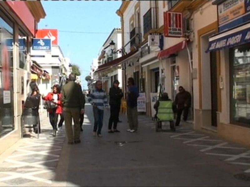 Calles de una ciudad con tiendas y gente caminando.