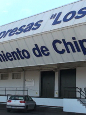 Edificio de empresas "Los Ma", ubicado en el Ayuntamiento de Chipiona, con un coche estacionado frente a la entrada.