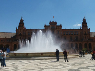 Plaza de España, Sevilla, con fuente y arquitectura histórica bajo un cielo azul claro.