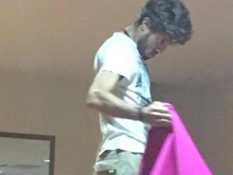 Persona sosteniendo un objeto púrpura en un interior minimalista.